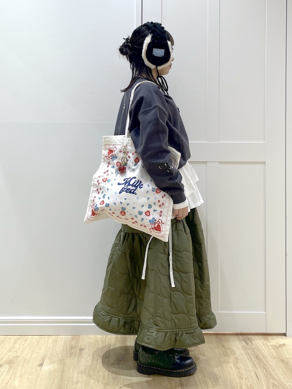 グリーン系のスカート、ホワイト系のTシャツ/カットソー、ホワイト系のトートバッグを着用したレディースの秋コーディネートの2枚目の写真