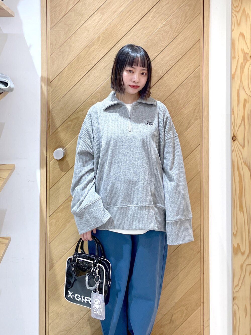 ブラック系のショルダーバッグ、グレー系のスウェット、ブルー系のその他パンツを着用したレディースの春コーディネートの2枚目の写真