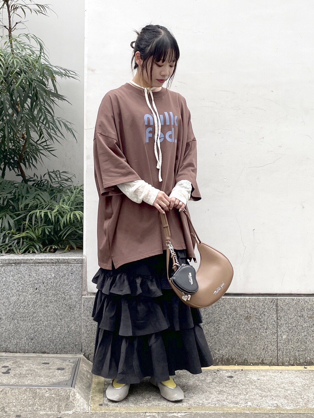 ブラック系のスカート、ホワイト系のTシャツ/カットソー、ブラウン系のTシャツ/カットソーを着用したレディースの秋コーディネートの2枚目の写真
