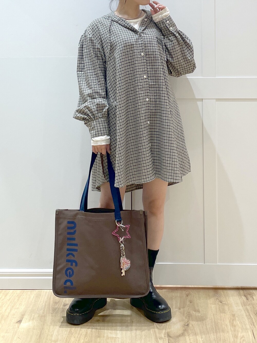 ブラック系のブーツ、ホワイト系のTシャツ/カットソー、ベージュ系のシャツ/ブラウスを着用したレディースの夏コーディネートの2枚目の写真