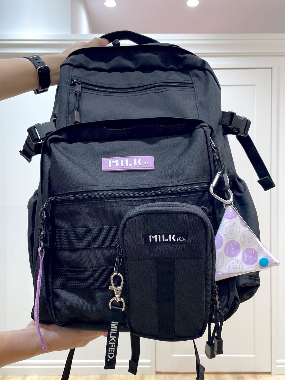 パープル系のバックパック/リュック、ブラック系のショルダーバッグ、ブラック系のブーツを着用したレディースの夏コーディネートの6枚目の写真