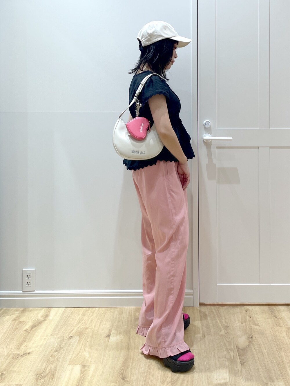 ホワイト系のハンドバッグ、ブラック系のサンダル、ブラック系のシャツ/ブラウスを着用したレディースの夏コーディネートの2枚目の写真