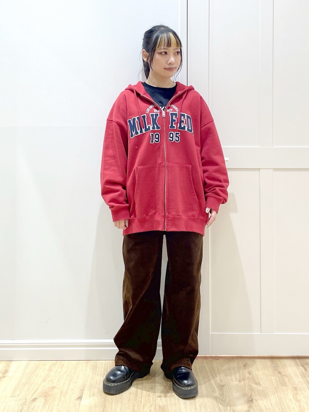 ブラック系のTシャツ/カットソー、レッド系のパーカー、ブラック系のブルゾンを着用したレディースの秋コーディネートの6枚目の写真