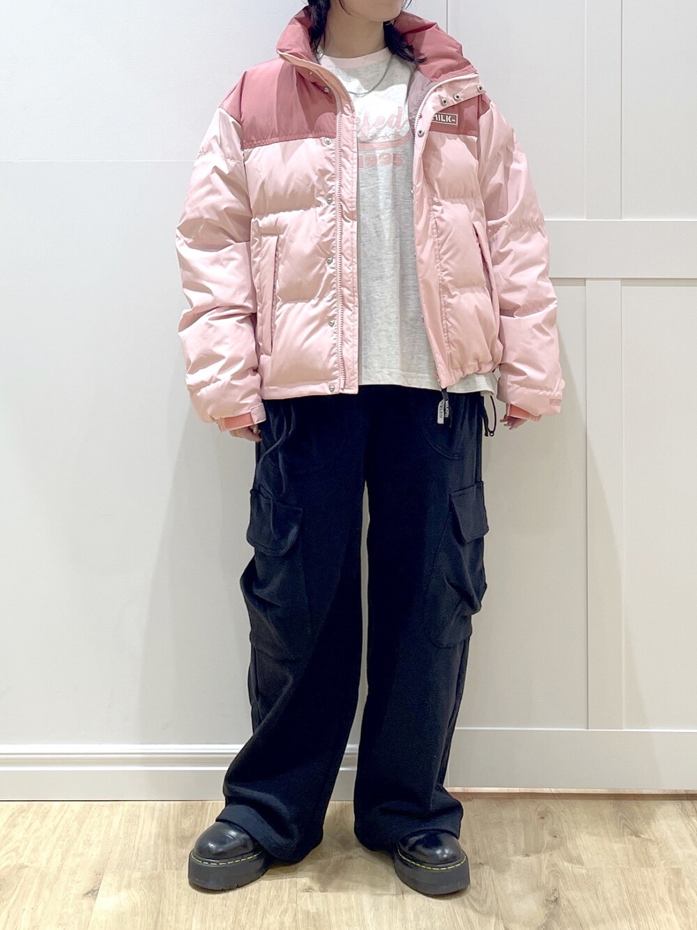 ブラック系のスウェットパンツ、ピンク系のダウンジャケット/コート、ベージュ系のTシャツ/カットソーを着用したレディースの冬コーディネートの8枚目の写真