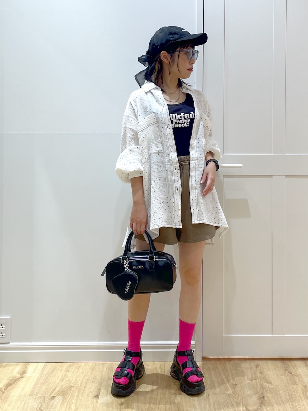 ブラック系のショルダーバッグ、ブラック系のサンダル、ブラック系のタンクトップを着用したレディースの夏コーディネートの4枚目の写真