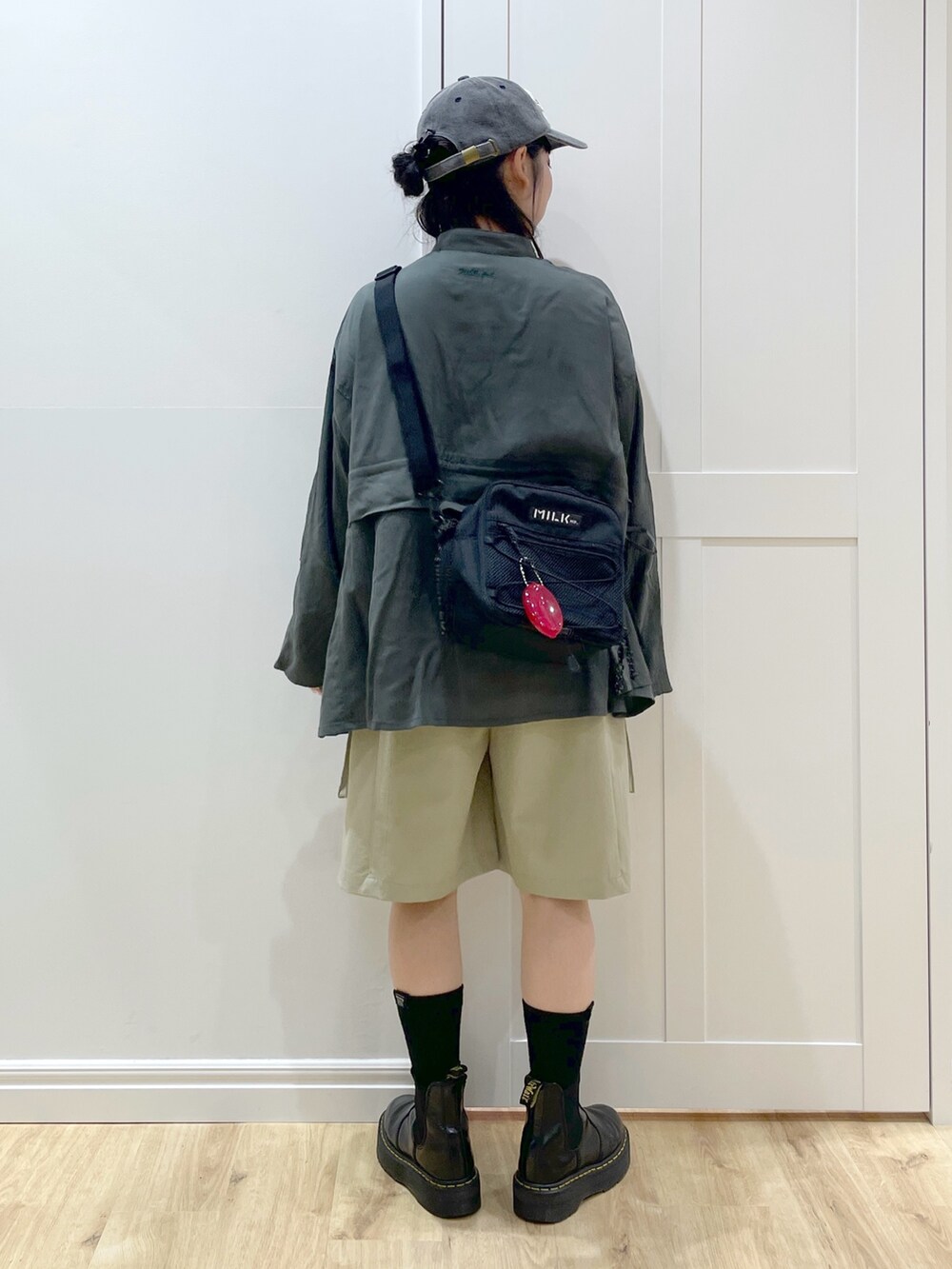 ブラック系のブーツ、グリーン系のシャツ/ブラウス、レッド系のショルダーバッグを着用したレディースの夏コーディネートの4枚目の写真