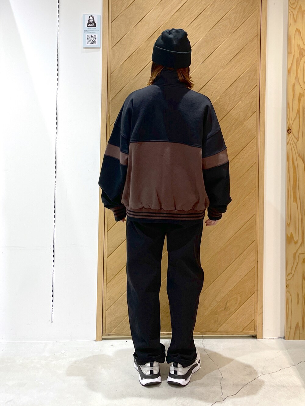 ブラック系のデニムパンツ、ブラック系のスウェット、ホワイト系のスニーカーを着用したレディースの冬コーディネートの2枚目の写真
