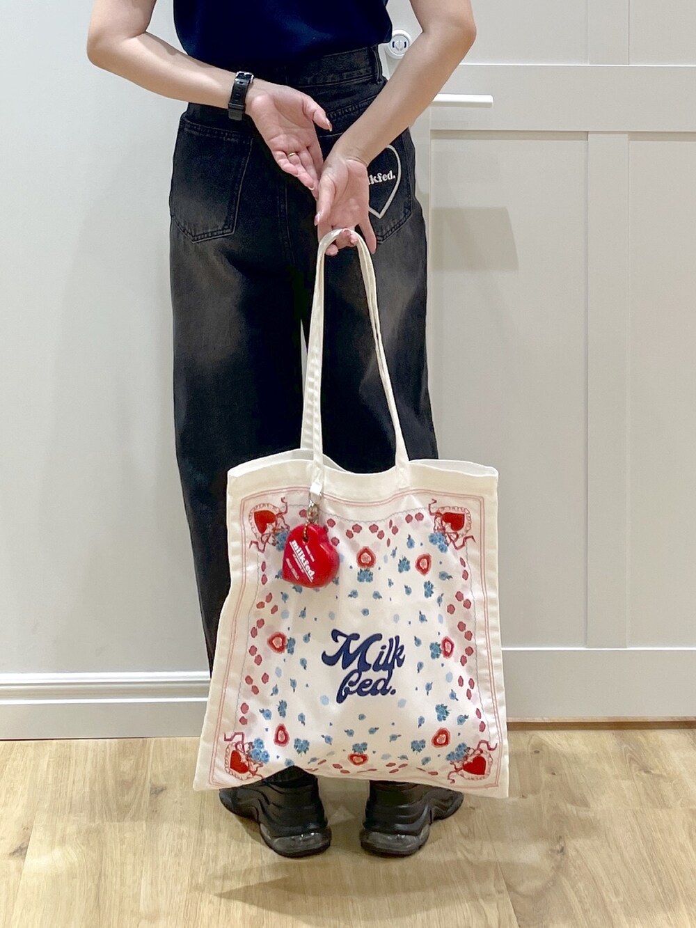 ブルー系のニット/セーター、ブラック系のデニムパンツ、ブラック系のサンダルを着用したレディースの夏コーディネートの4枚目の写真