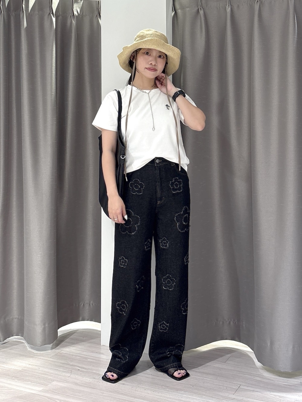 ブラック系のサンダル、ホワイト系のTシャツ/カットソー、ブラック系のデニムパンツを着用したレディースの夏コーディネートの4枚目の写真