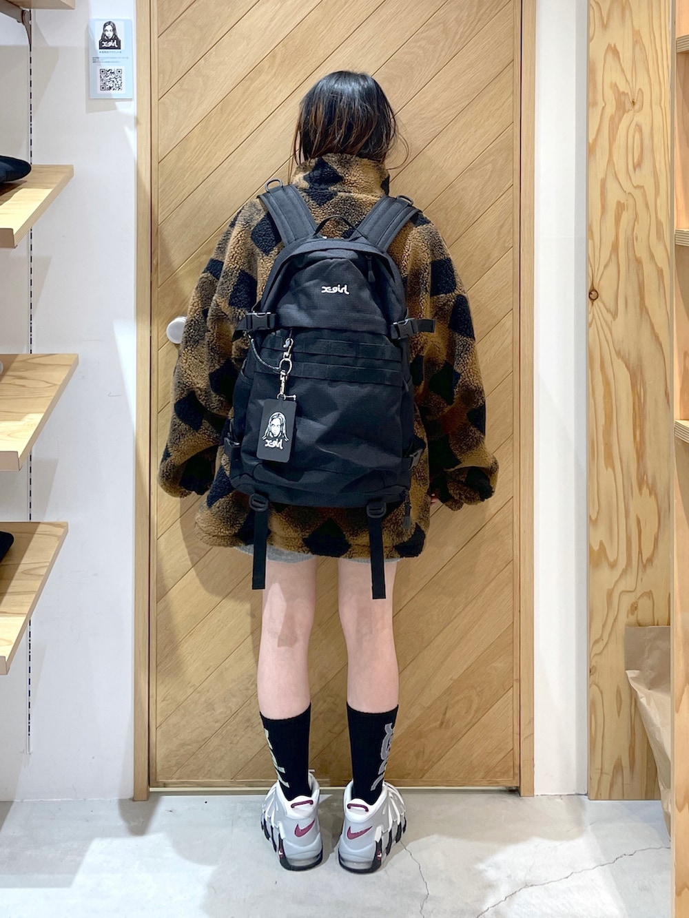 ホワイト系のスニーカー、ブラウン系のブルゾン、レッド系のバックパック/リュックを着用したレディースの冬コーディネートの3枚目の写真