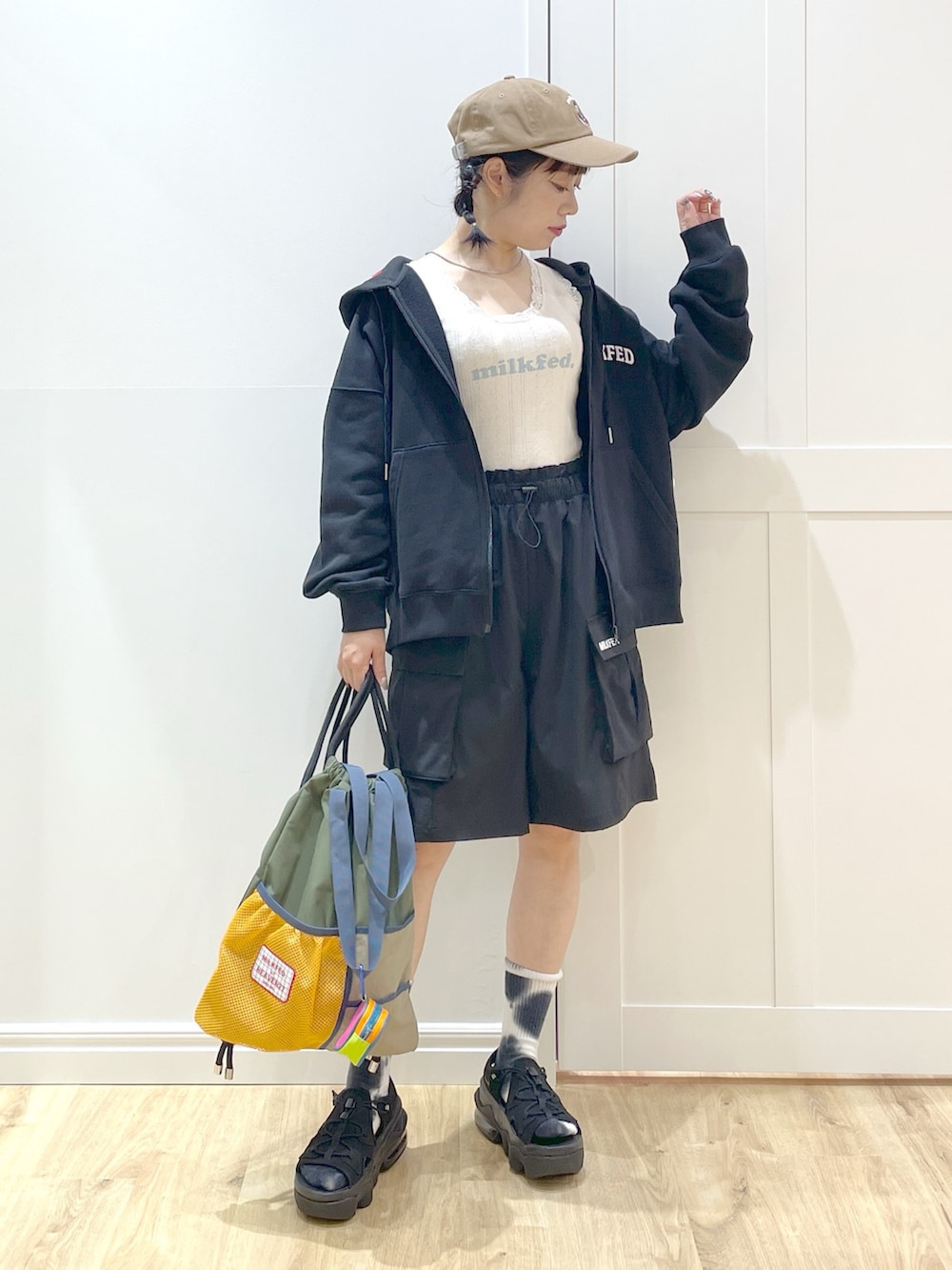 グリーン系のバックパック/リュック、ブラック系のパーカー、ホワイト系のタンクトップを着用したレディースの春コーディネートの2枚目の写真