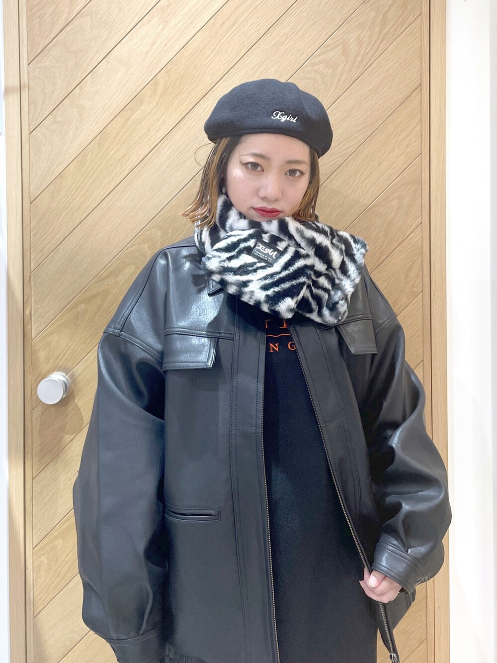 ブラック系のニット/セーター、ブラック系のライダースジャケット、ブラック系のハンドバッグを着用したレディースの秋コーディネートの2枚目の写真