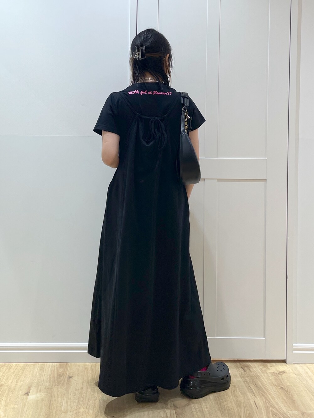 ブラック系のワンピース、ブラック系のTシャツ/カットソー、ブラック系のハンドバッグを着用したレディースの春コーディネートの2枚目の写真