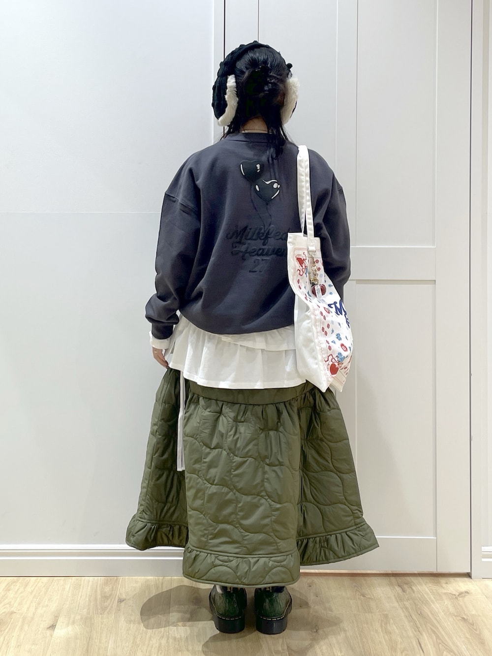 グリーン系のスカート、ホワイト系のTシャツ/カットソー、ホワイト系のトートバッグを着用したレディースの秋コーディネートの3枚目の写真