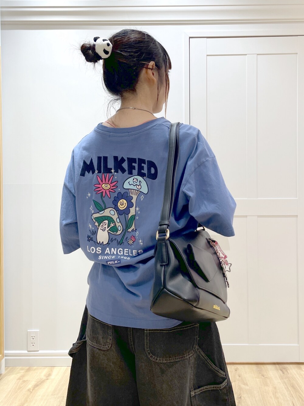 ブルー系のTシャツ/カットソー、ブラック系のデニムパンツ、ブラック系のショルダーバッグを着用したレディースの秋コーディネートの3枚目の写真