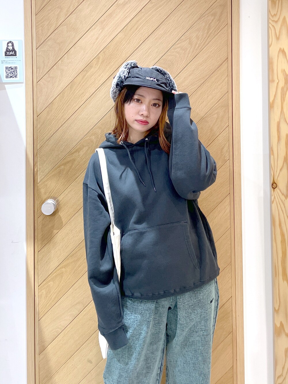 グリーン系のスウェットパンツ、ブラック系のブーツ、グレー系のパーカーを着用したレディースの秋コーディネートの3枚目の写真