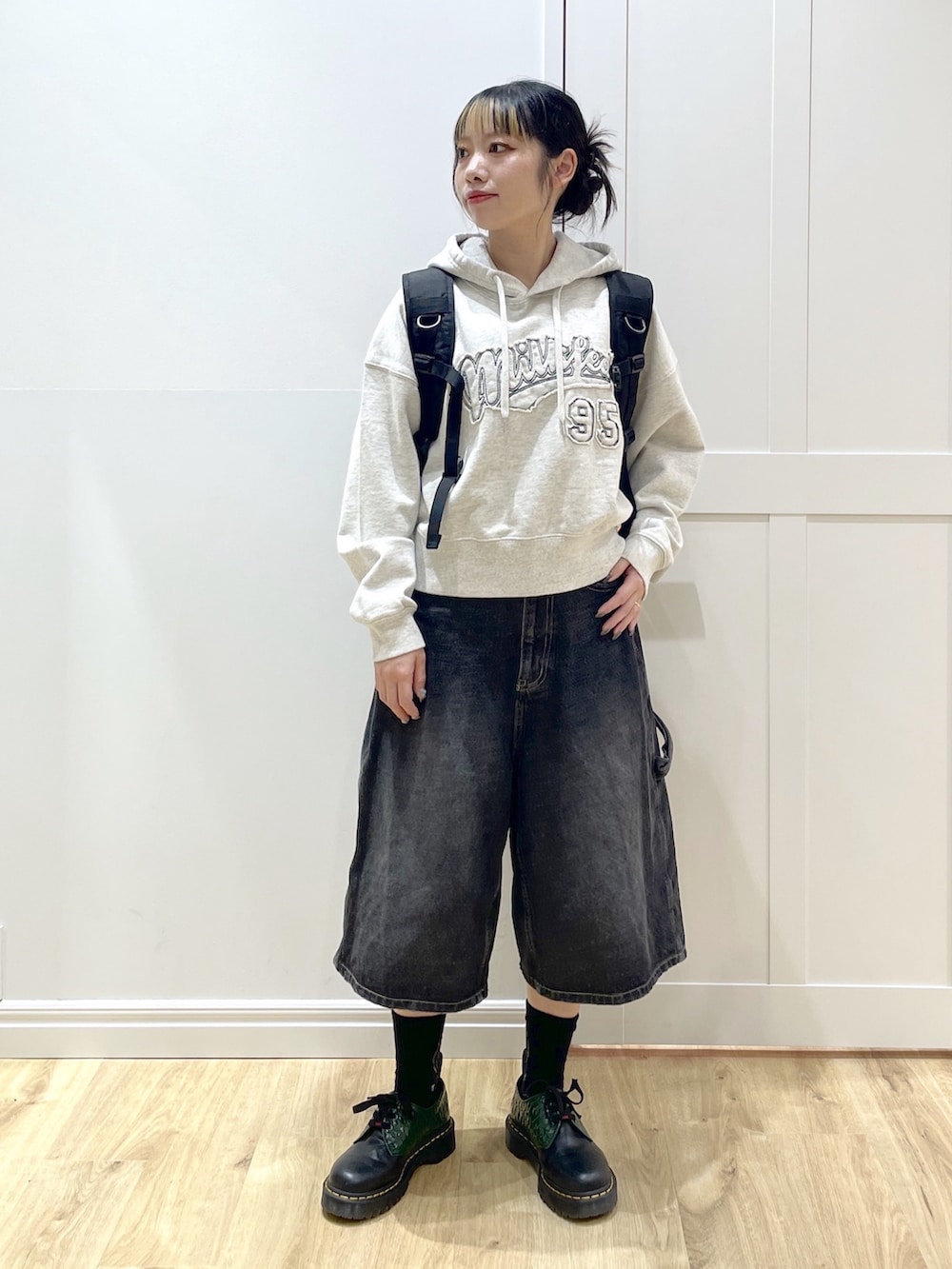 ブラック系のデニムパンツ、ベージュ系のパーカー、レッド系のバックパック/リュックを着用したレディースの冬コーディネートの2枚目の写真