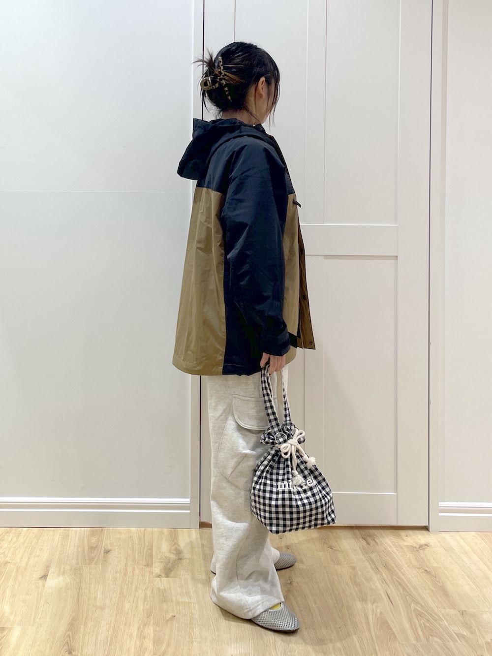 ベージュ系のスウェットパンツ、ベージュ系のマウンテンパーカー、ブラック系のTシャツ/カットソーを着用したレディースの秋コーディネートの3枚目の写真