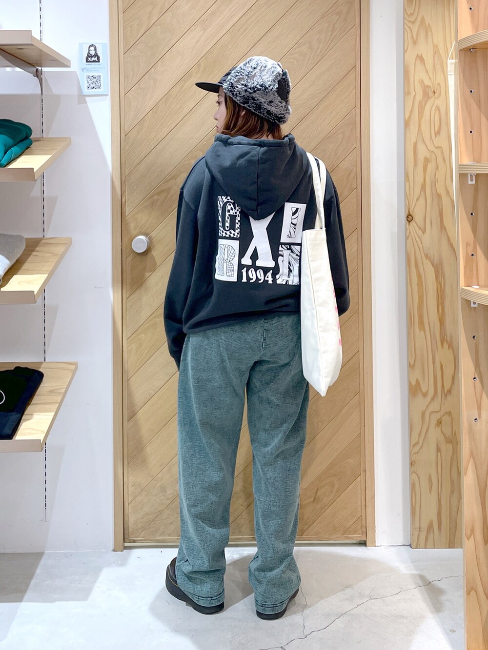 グリーン系のスウェットパンツ、ブラック系のブーツ、グレー系のパーカーを着用したレディースの秋コーディネートの2枚目の写真