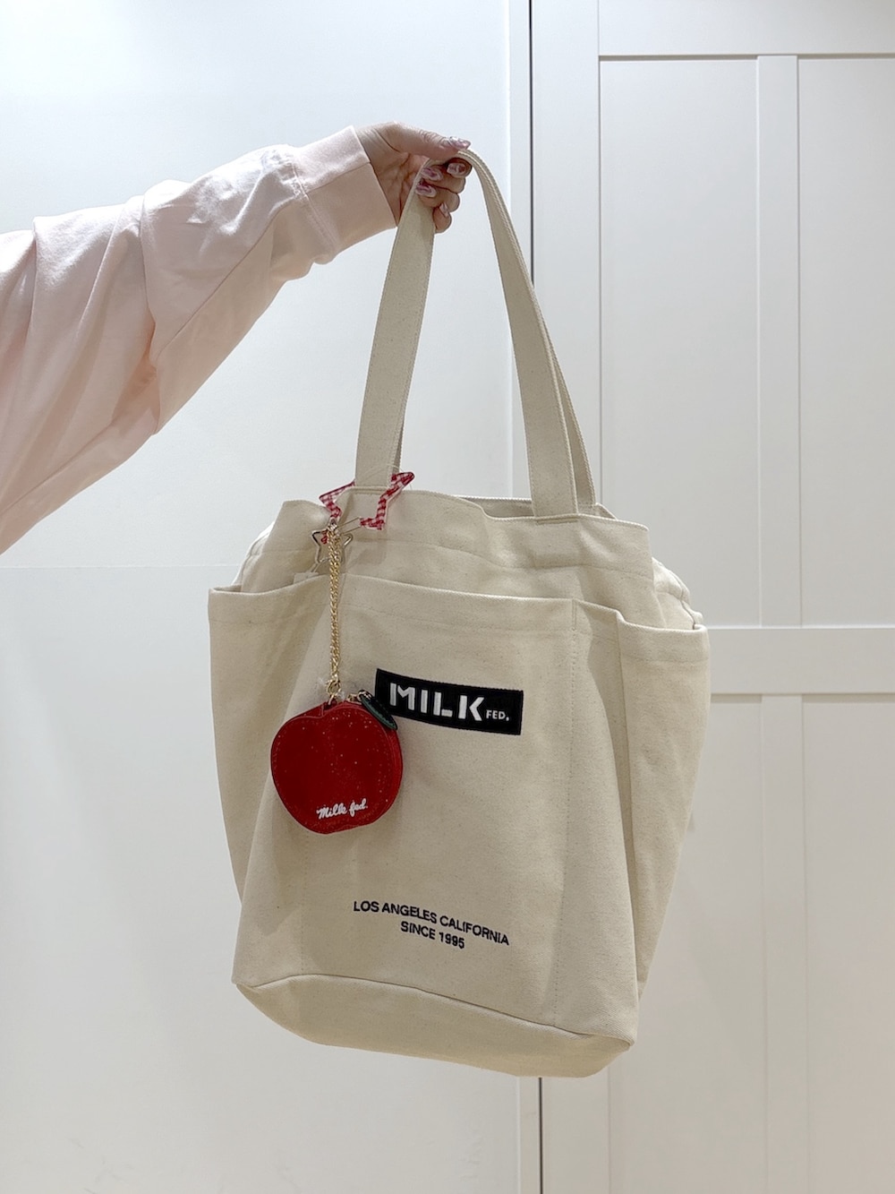 ホワイト系のTシャツ/カットソー、ブルー系のデニムパンツ、ホワイト系のトートバッグを着用したレディースの冬コーディネートの7枚目の写真