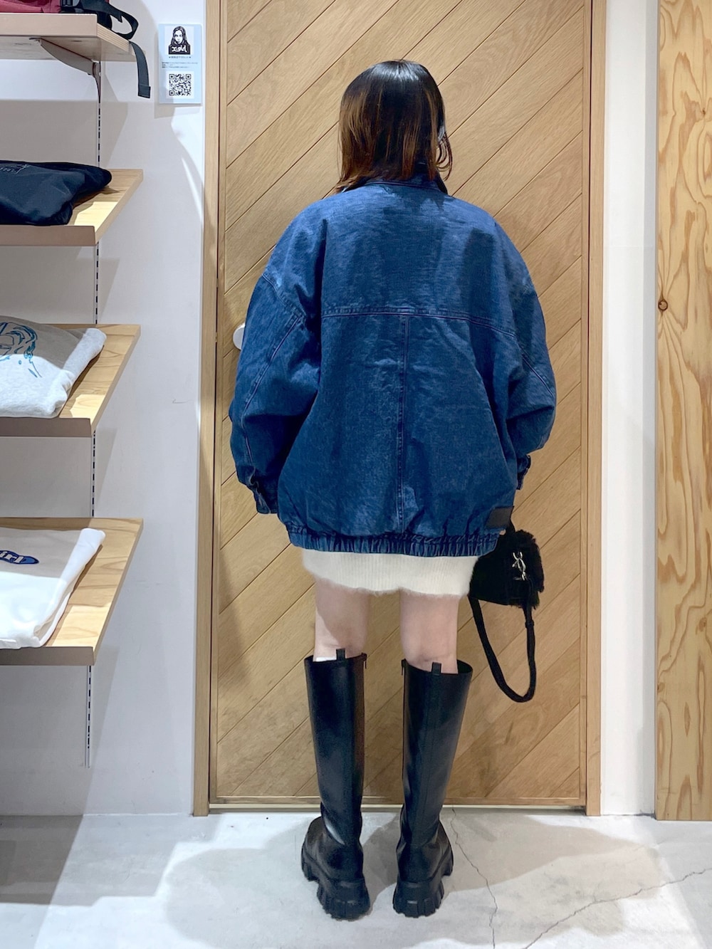 ブラック系のショルダーバッグ、ブラック系のブーツ、ホワイト系のニット/セーターを着用したレディースの冬コーディネートの3枚目の写真