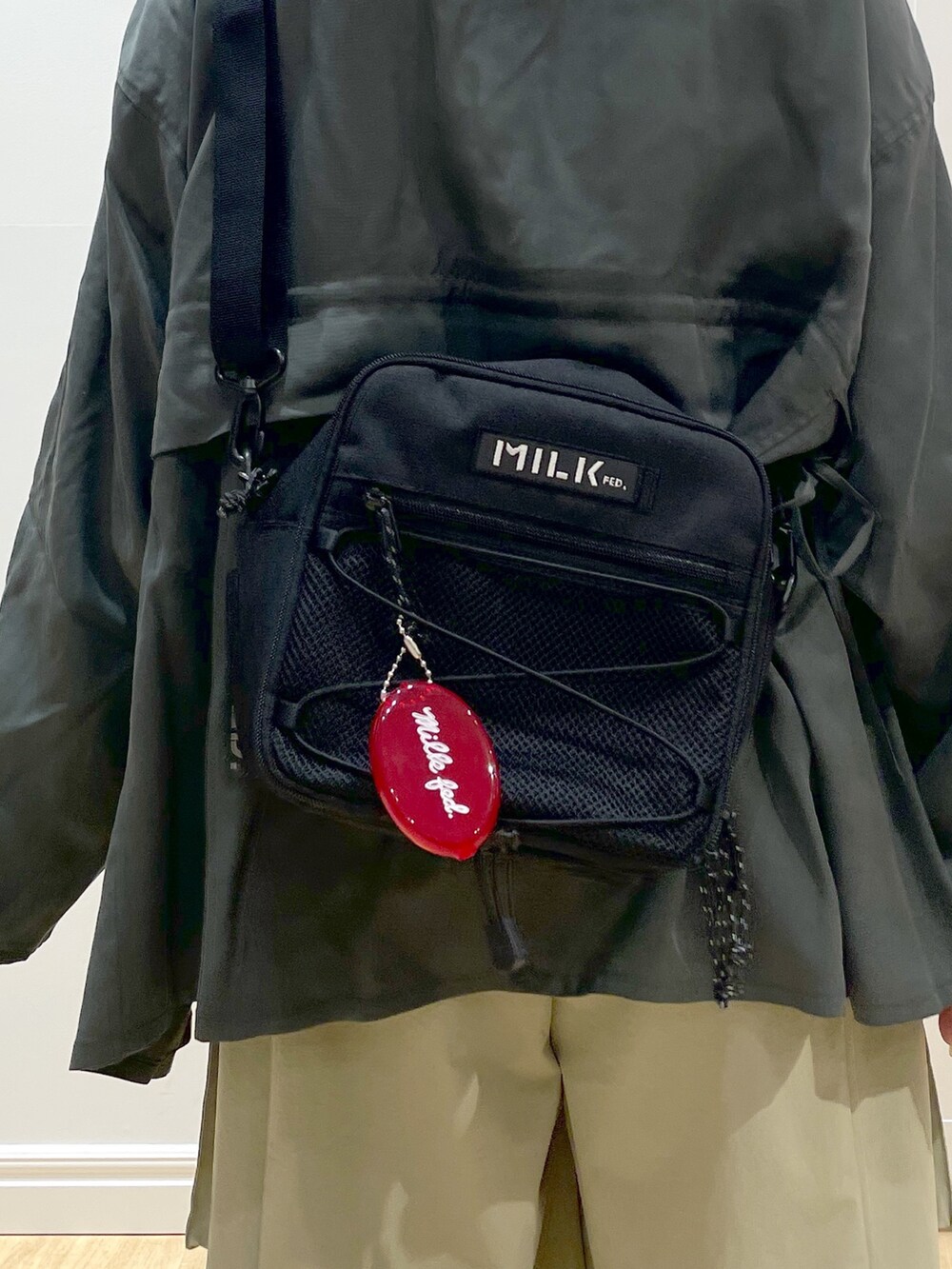 ブラック系のブーツ、グリーン系のシャツ/ブラウス、レッド系のショルダーバッグを着用したレディースの夏コーディネートの6枚目の写真