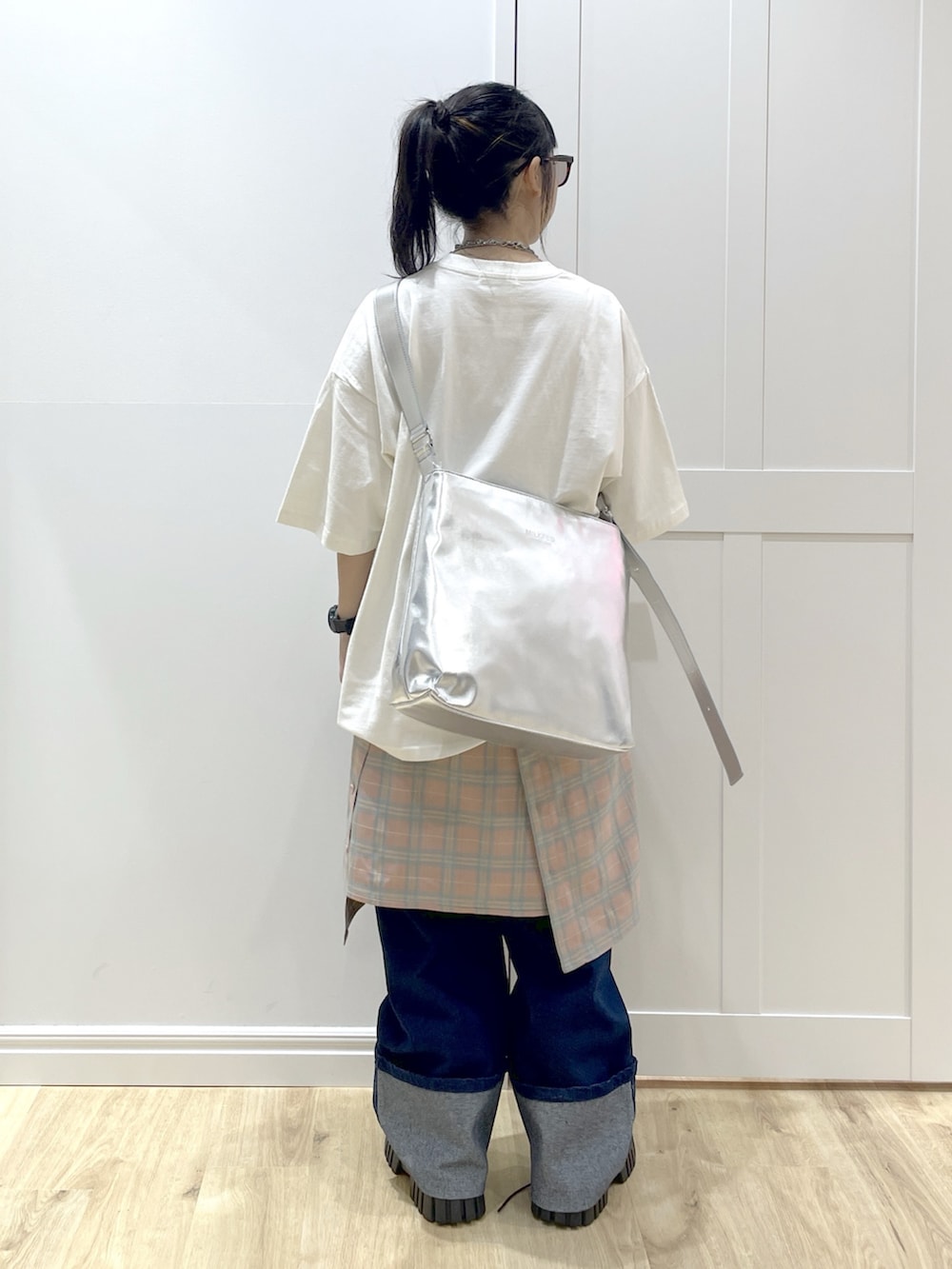 ブルー系のデニムパンツ、ピンク系のシャツ/ブラウス、シルバー系のショルダーバッグを着用したレディースの秋コーディネートの5枚目の写真