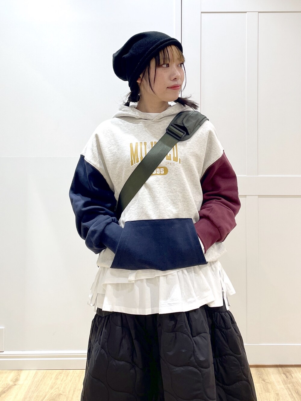 ブラック系のブーツ、グリーン系のメッセンジャーバッグ、ブラック系のスカートを着用したレディースの冬コーディネートの4枚目の写真