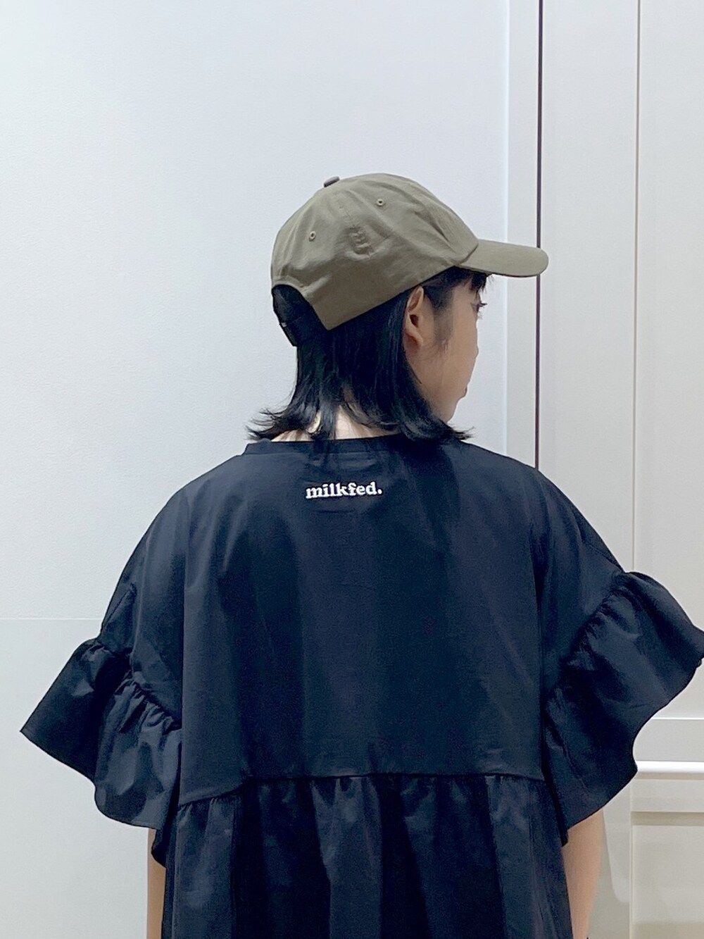 ブラック系のスカート、ブラック系のトートバッグ、ブラック系のラッシュガードを着用したレディースの春コーディネートの3枚目の写真