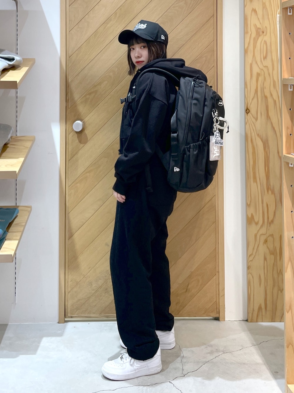 ブラック系のスウェットパンツ、ホワイト系のスニーカー、ブラック系のパーカーを着用したレディースの春コーディネートの2枚目の写真