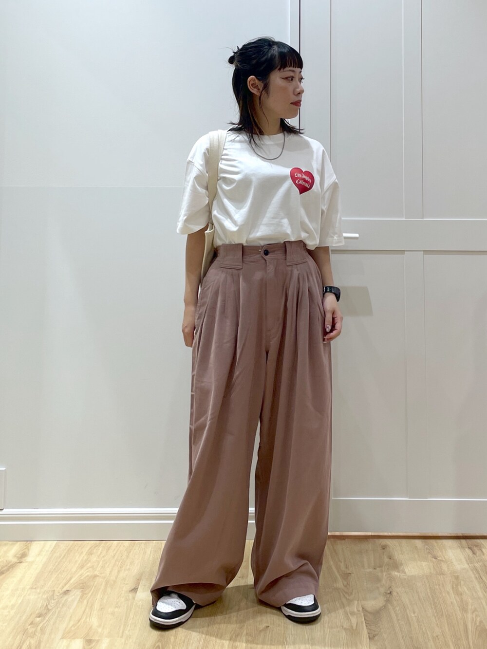 ホワイト系のTシャツ/カットソー、ホワイト系のスニーカー、ホワイト系のトートバッグを着用したレディースの夏コーディネートの4枚目の写真