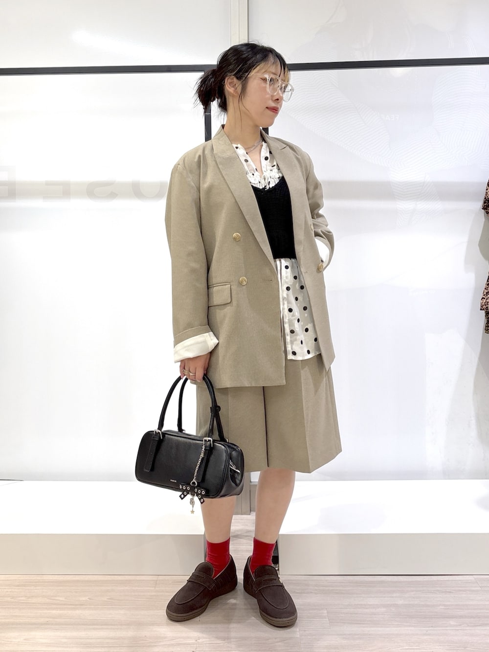 ホワイト系のシャツ/ブラウス、ブラック系のニット/セーター、ベージュ系のテーラードジャケットを着用したレディースの春コーディネートの6枚目の写真