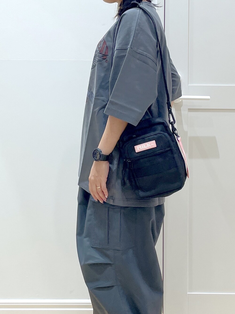 ピンク系のショルダーバッグ、グレー系のTシャツ/カットソー、グレー系のその他パンツを着用したレディースの夏コーディネートの4枚目の写真