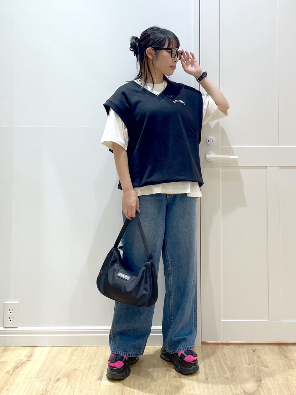 ブラック系のベスト、ブルー系のデニムパンツ、ホワイト系のTシャツ/カットソーを着用したレディースの夏コーディネートの3枚目の写真