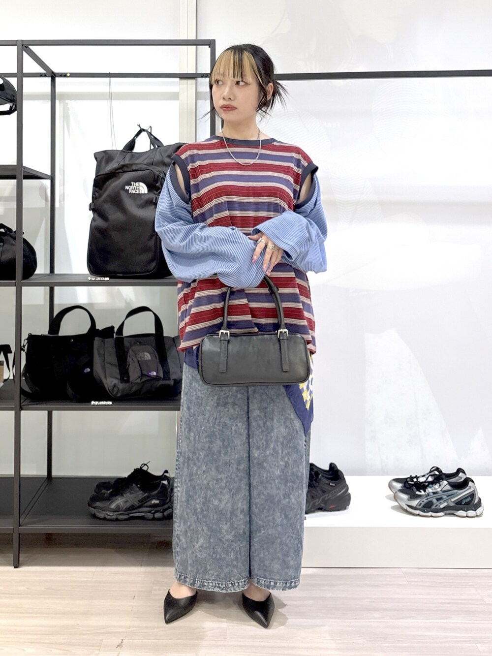 ブラック系のショルダーバッグ、ブラック系のその他シューズ、ブルー系のTシャツ/カットソーを着用したレディースの春コーディネートの2枚目の写真