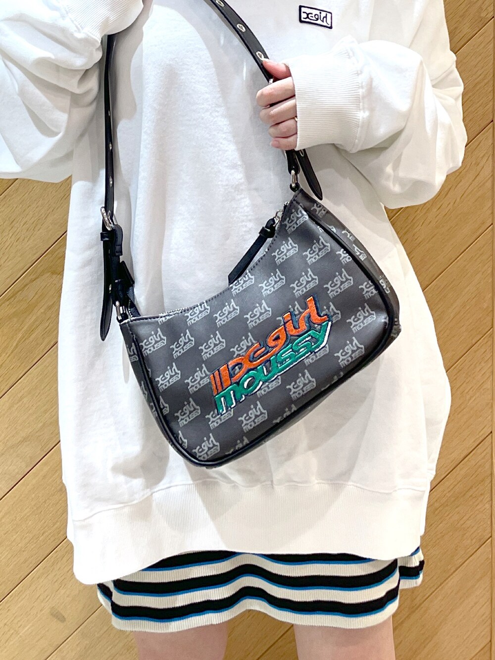 ホワイト系のスウェット、ブラック系のワンピース、ブラック系のブーツを着用したレディースの春コーディネートの3枚目の写真