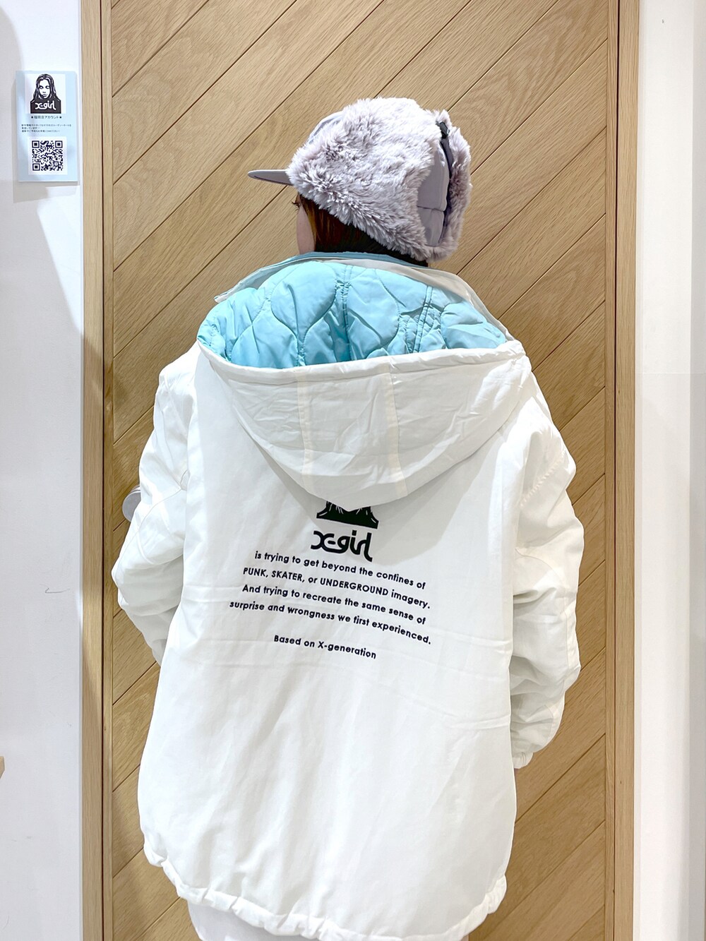 ホワイト系のTシャツ/カットソー、ホワイト系のナイロンジャケット、ブラック系のブーツを着用したレディースの秋コーディネートの3枚目の写真