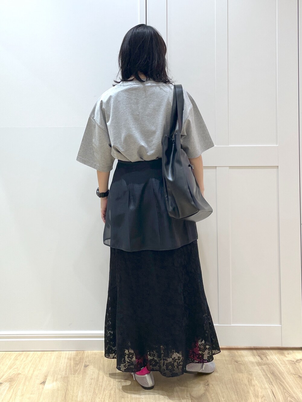ブラック系のスカート、ブラック系のトートバッグ、グレー系のTシャツ/カットソーを着用したレディースの春コーディネートの3枚目の写真