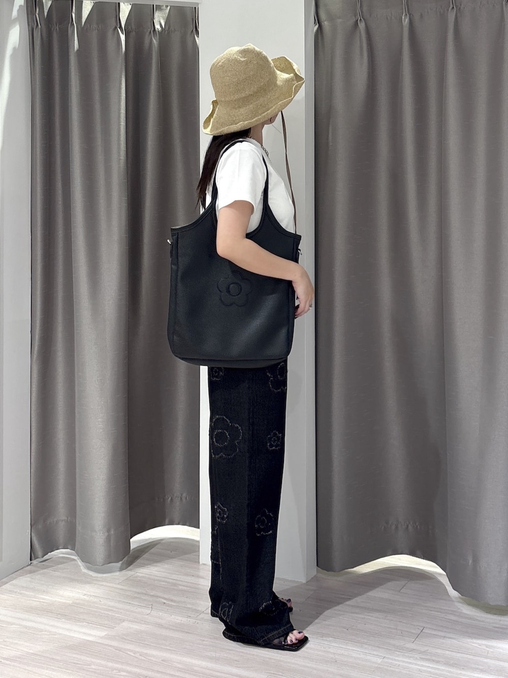 ブラック系のサンダル、ホワイト系のTシャツ/カットソー、ブラック系のデニムパンツを着用したレディースの夏コーディネートの2枚目の写真