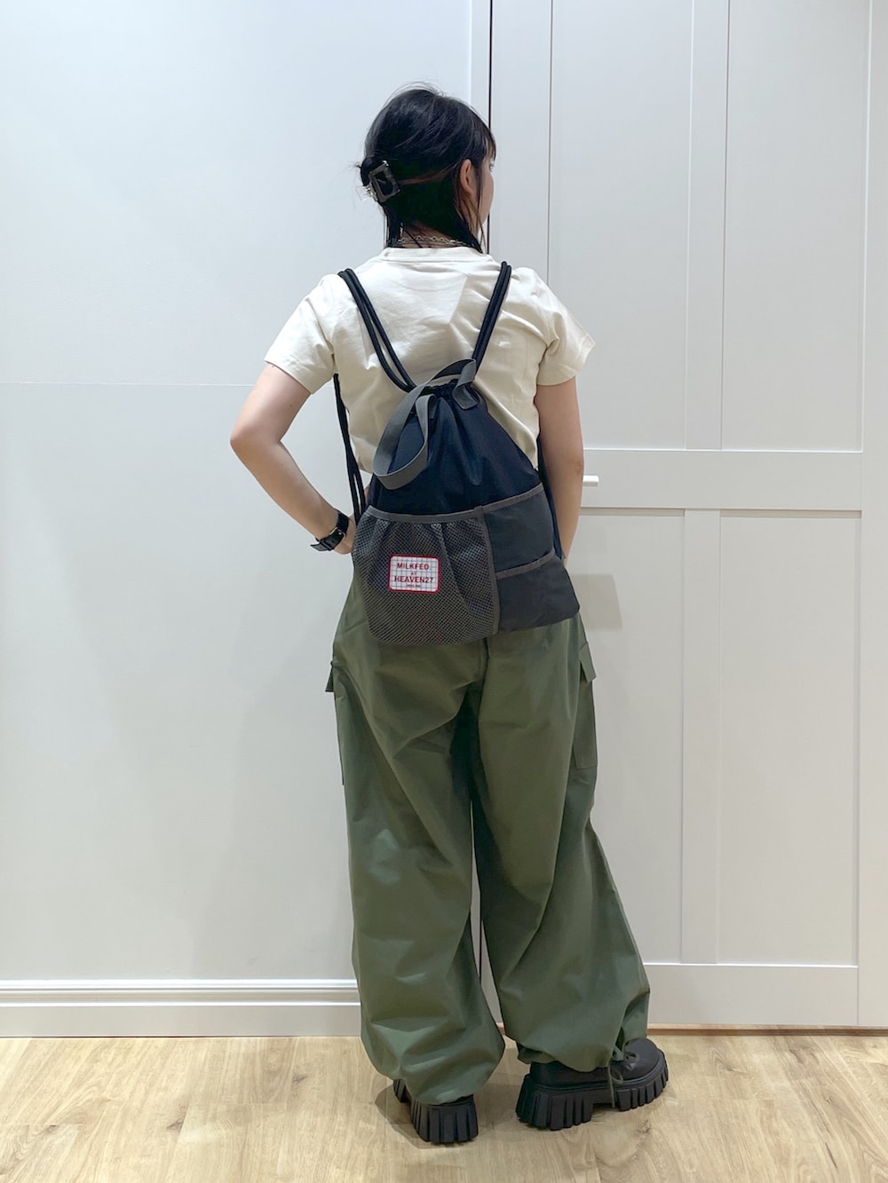 グリーン系のその他パンツ、ホワイト系のTシャツ/カットソー、ブラック系のバックパック/リュックを着用したレディースの春コーディネートの3枚目の写真
