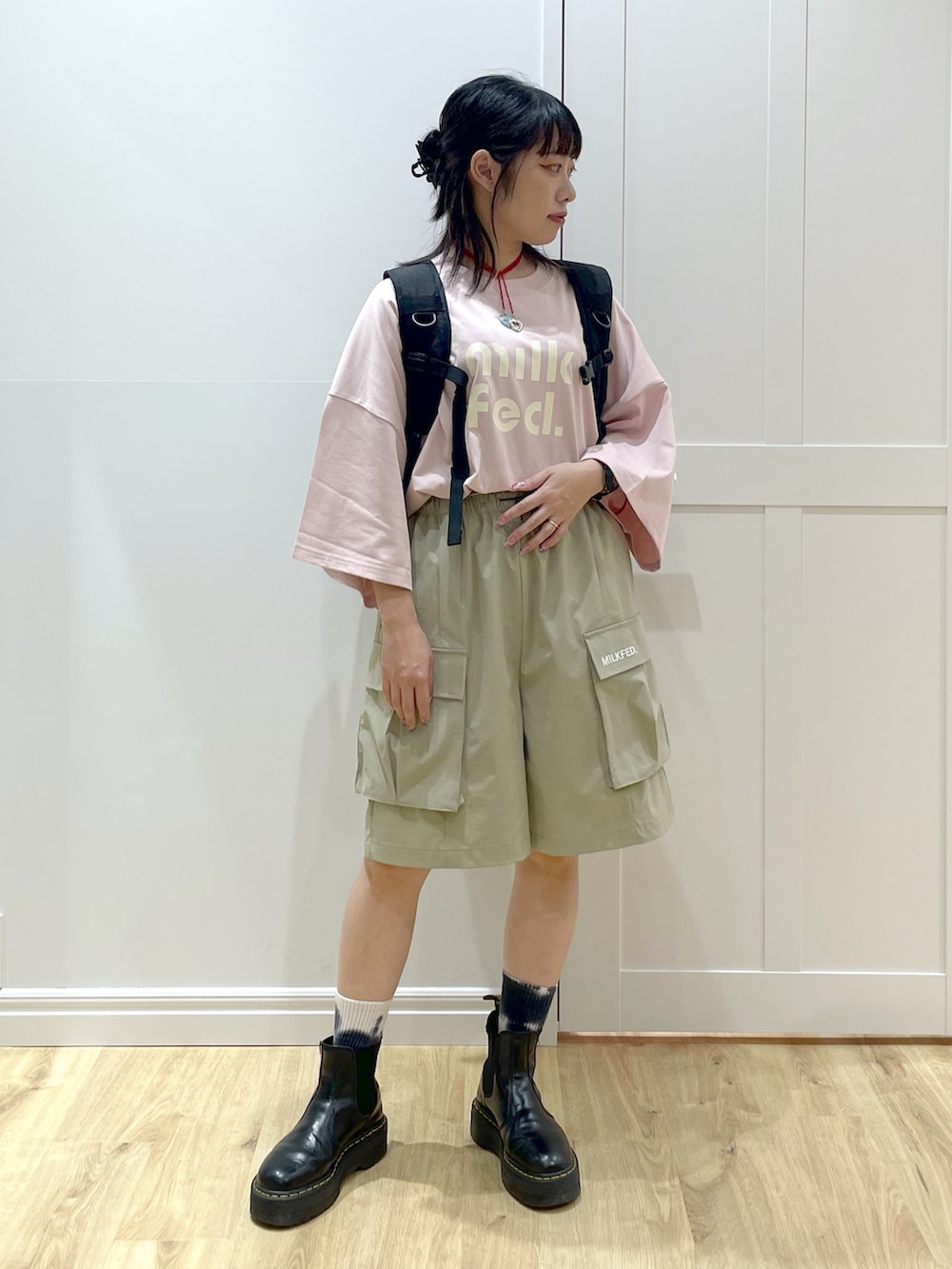 ピンク系のTシャツ/カットソー、ブラック系のブーツ、レッド系のバックパック/リュックを着用したレディースの夏コーディネートの2枚目の写真