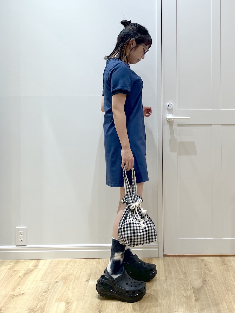 ブラック系のサンダル、ブラック系のデニムパンツ、ブルー系のワンピースを着用したレディースの夏コーディネートの2枚目の写真