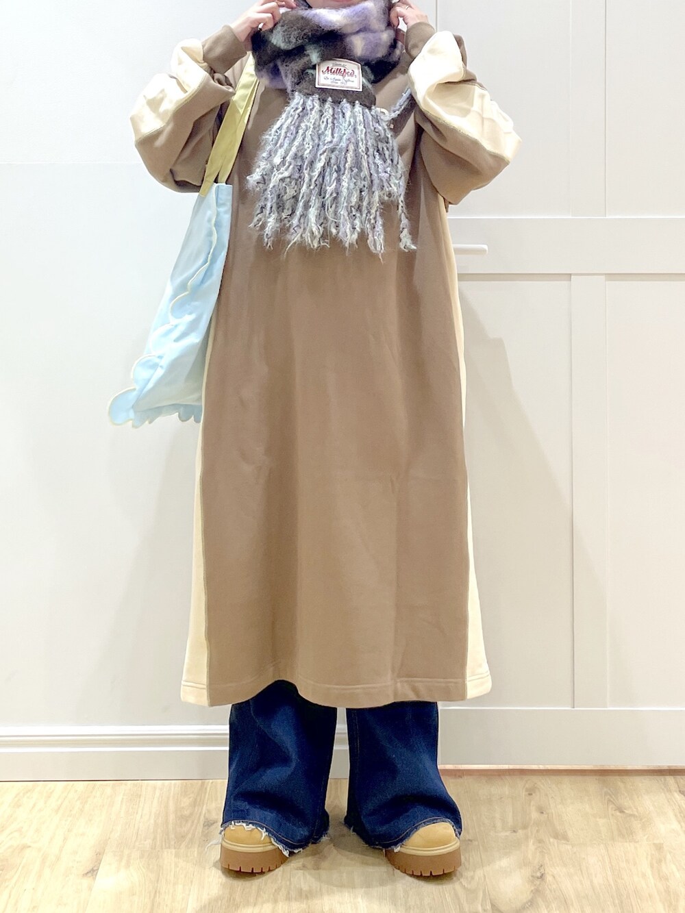 ベージュ系のブーツ、ブルー系のトートバッグ、ブラウン系のワンピースを着用したレディースの秋コーディネートの5枚目の写真