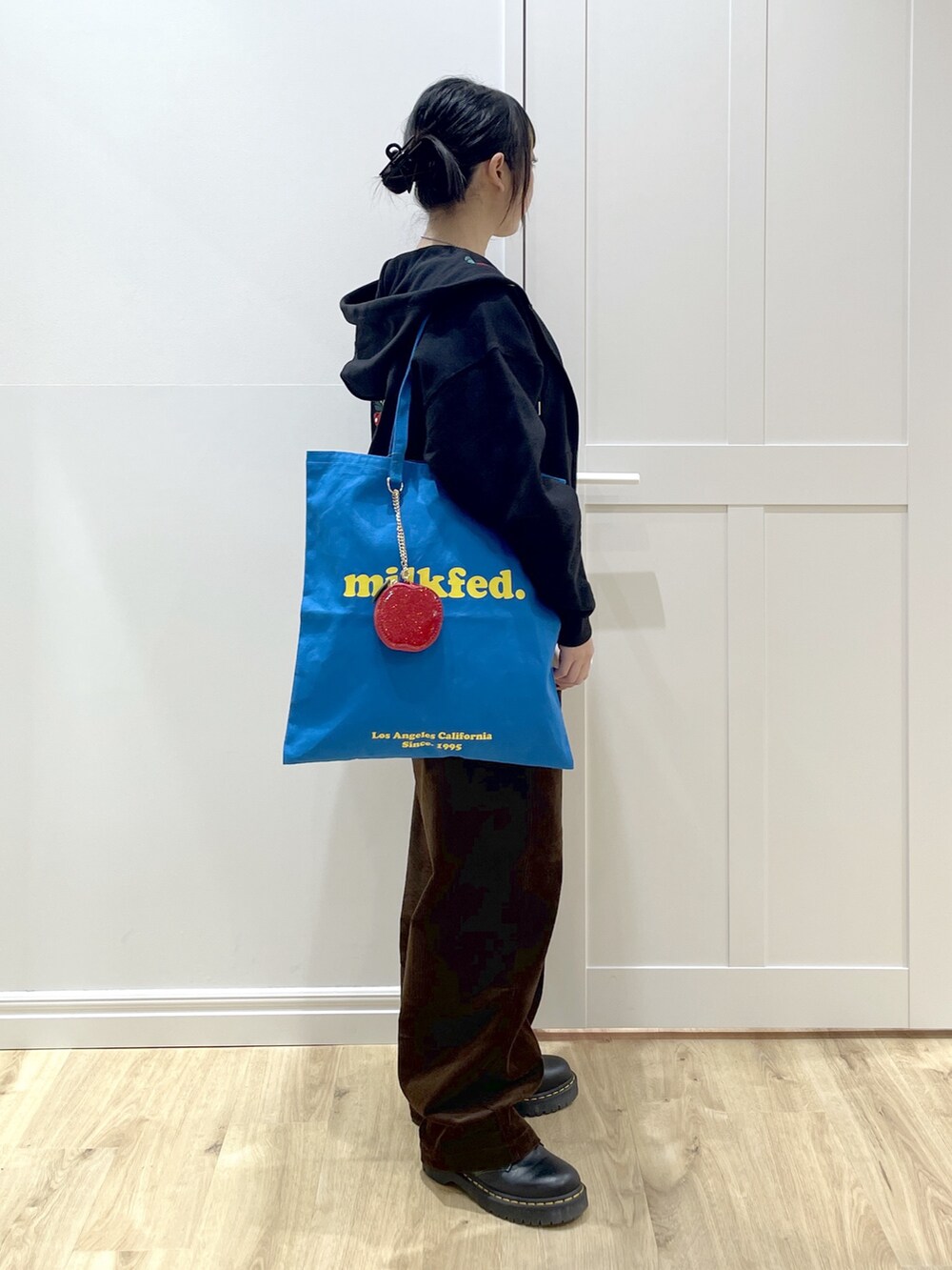 ブルー系のトートバッグ、ホワイト系のTシャツ/カットソー、ブラック系のパーカーを着用したレディースの冬コーディネートの2枚目の写真