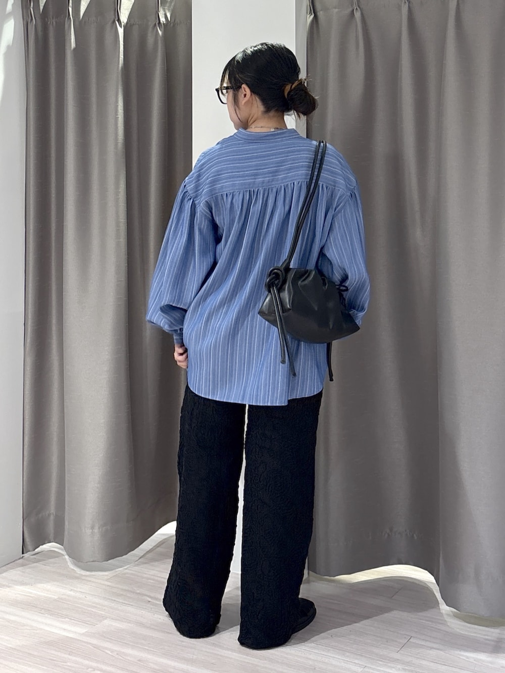 ブルー系のシャツ/ブラウス、ブラウン系のタンクトップ、ブラック系のその他パンツを着用したレディースの秋コーディネートの3枚目の写真