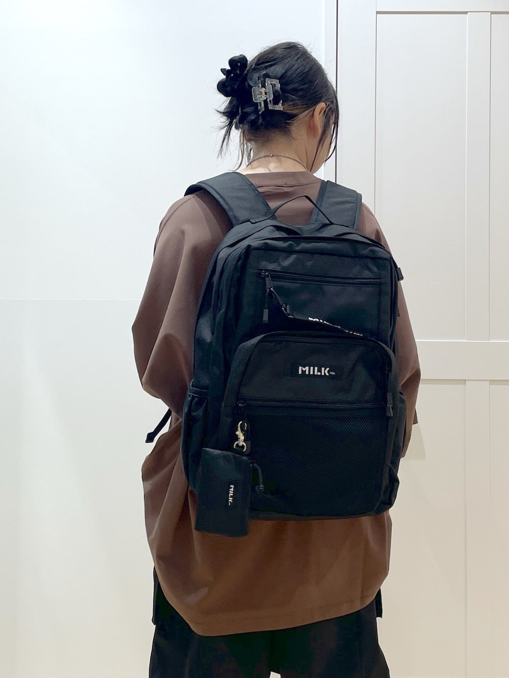 ブラック系のバックパック/リュック、ブラウン系のTシャツ/カットソー、ブラック系のサンダルを着用したレディースの春コーディネートの5枚目の写真