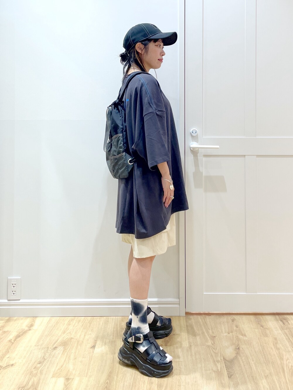 ブラック系のサンダル、グレー系のTシャツ/カットソー、ブラック系のバックパック/リュックを着用したレディースの夏コーディネートの4枚目の写真