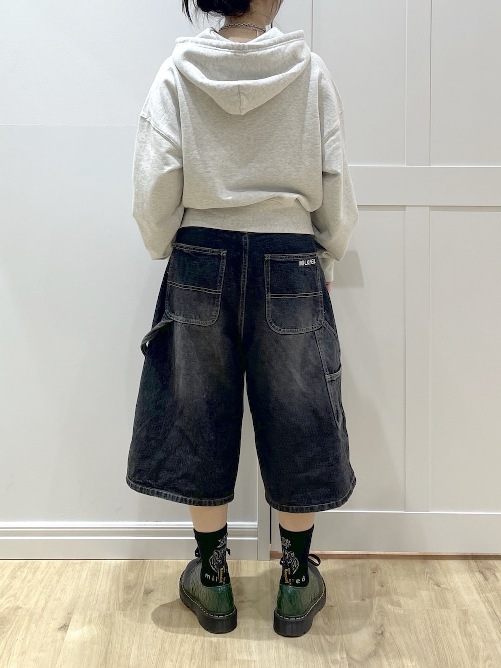 ブラック系のデニムパンツ、ベージュ系のパーカー、レッド系のバックパック/リュックを着用したレディースの冬コーディネートの6枚目の写真