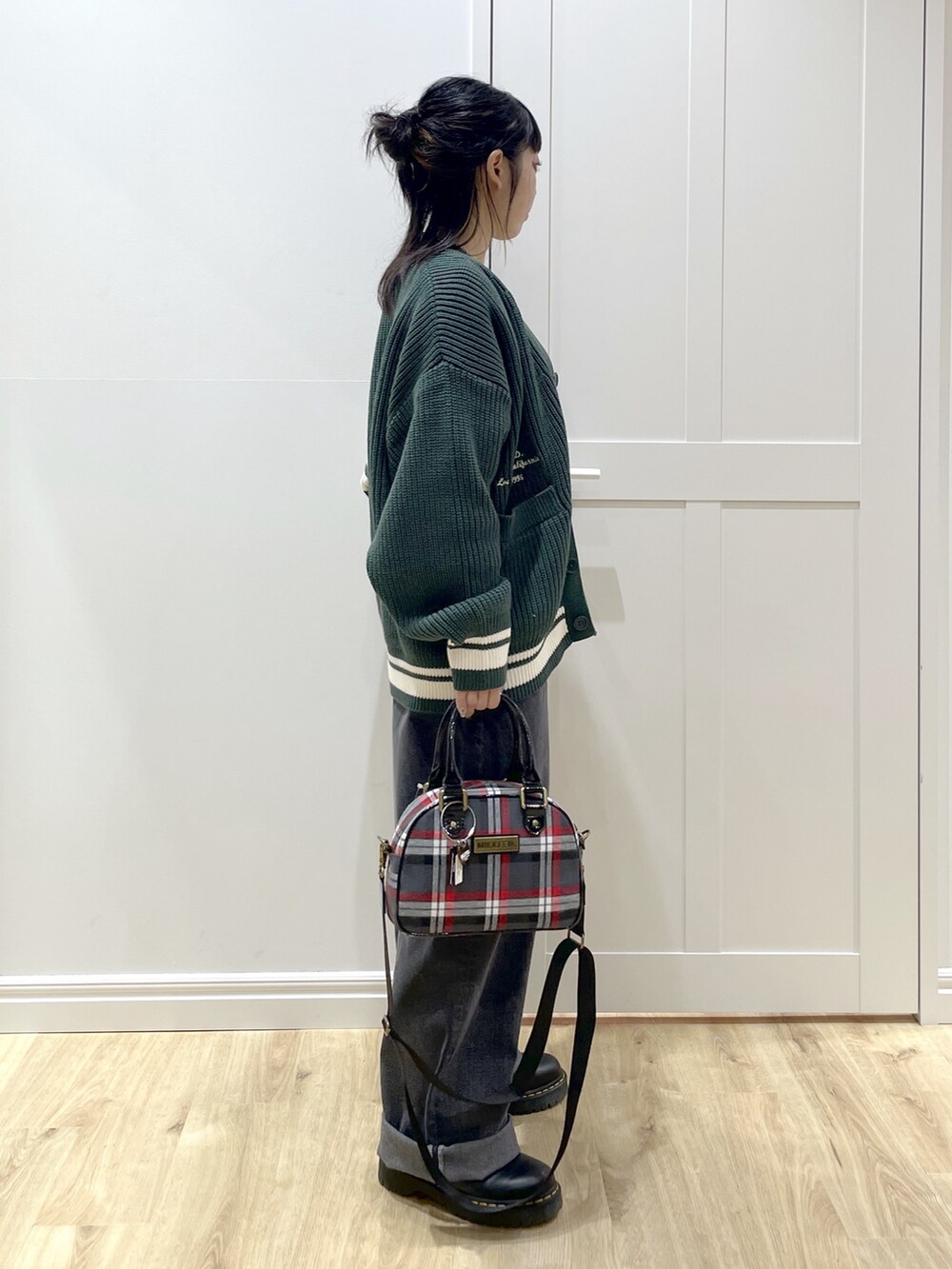 グリーン系のカーディガン/ボレロ、ホワイト系のTシャツ/カットソー、ブラック系のデニムパンツを着用したレディースの秋コーディネートの2枚目の写真