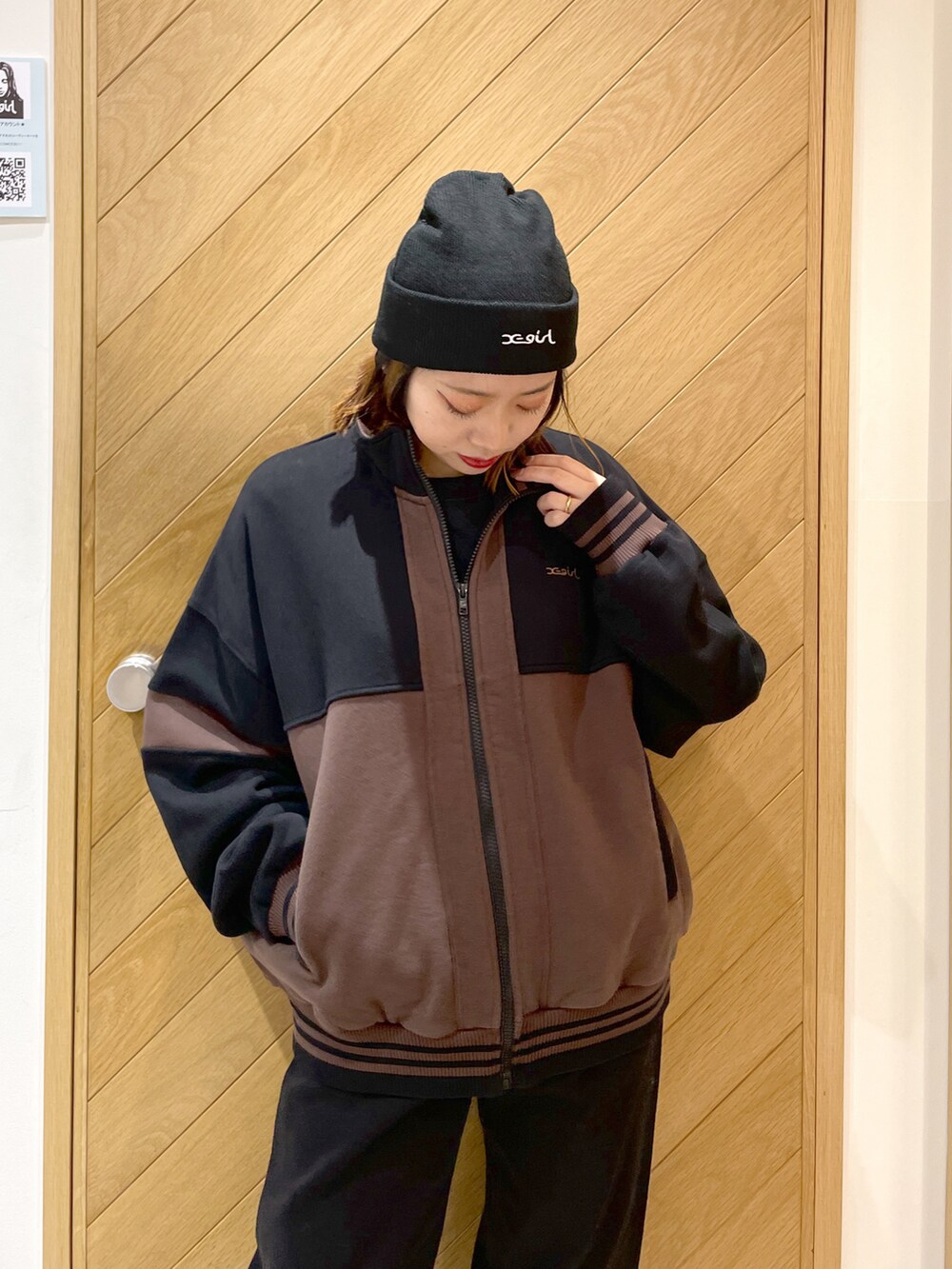 ブラック系のデニムパンツ、ブラック系のスウェット、ホワイト系のスニーカーを着用したレディースの冬コーディネートの3枚目の写真